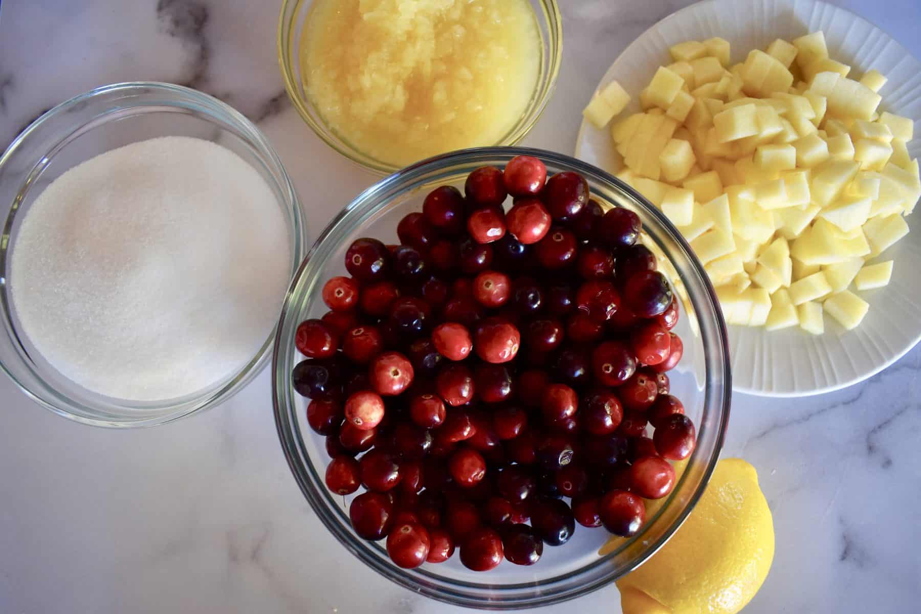 cranberries, sugar, pineapple, lemon, and apple for making cranberry pineapple sauce. 