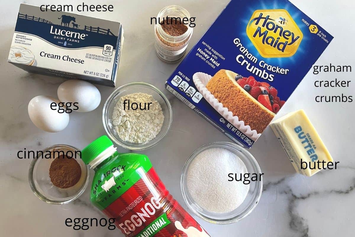 overhead photo of ingredients including cream cheese, eggnog, flour, sugar, butter, cinnamon and nutmeg. 