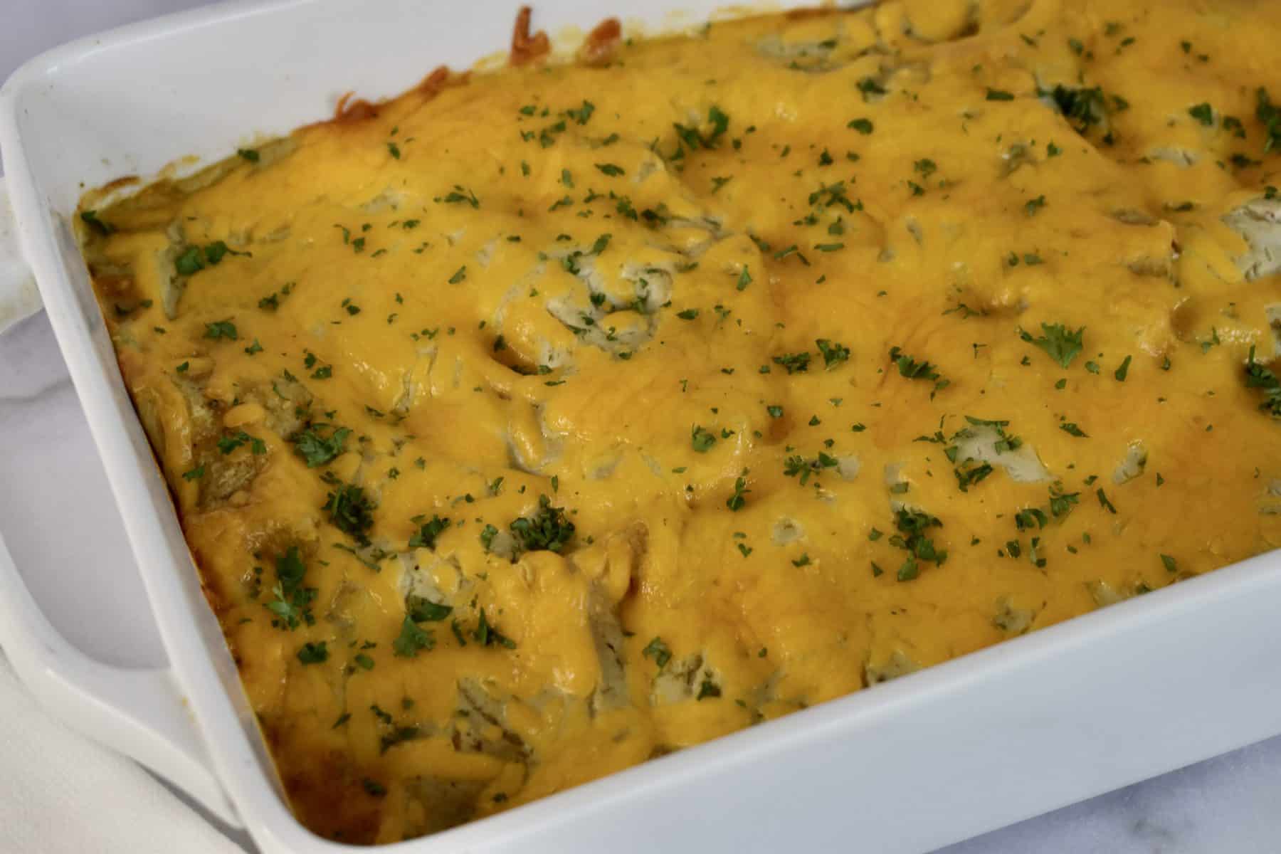 Green Enchilada Casserole in a white baking dish. 