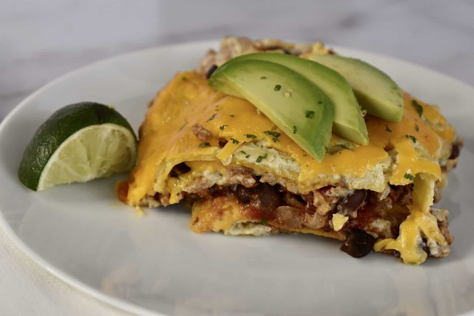 Green Enchilada Casserole with sliced avocado on top. 