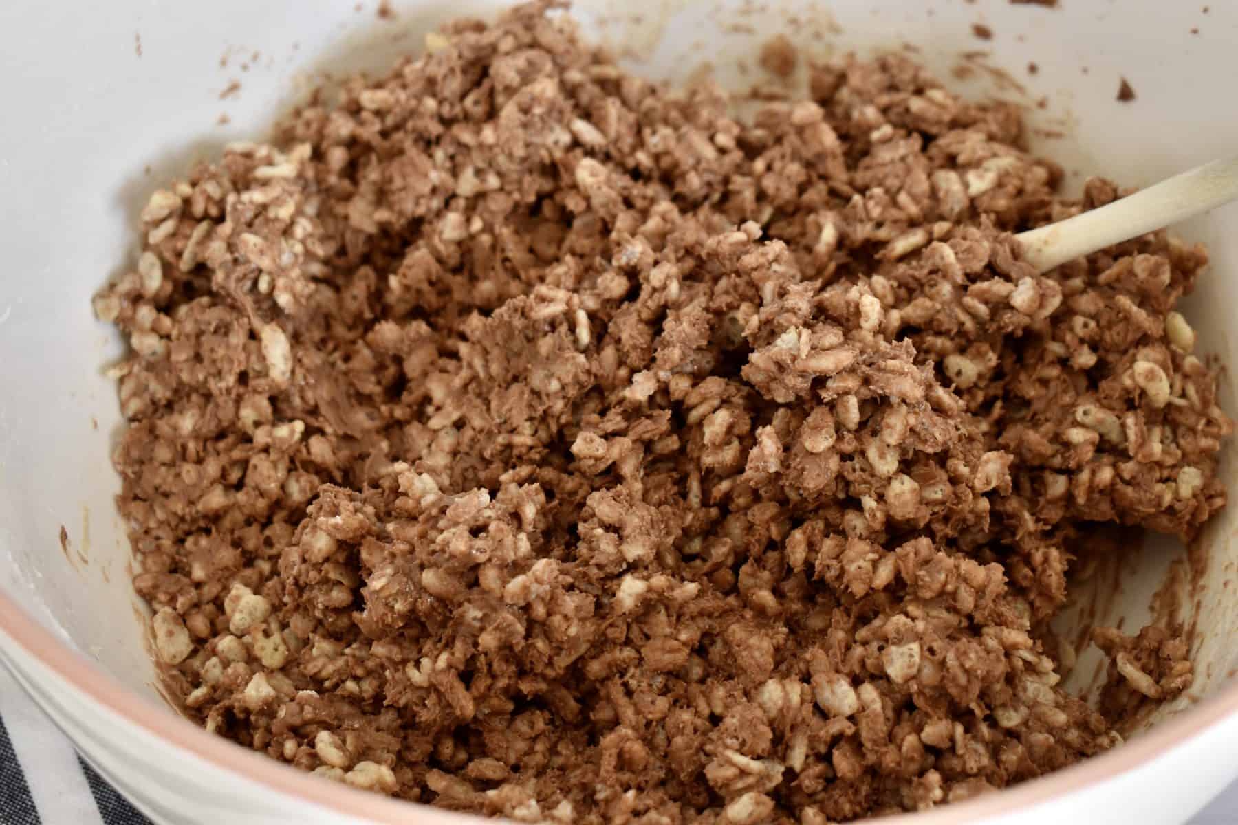 Nutella, peanut butter, Rice Krispies, and powdered sugar and combined together in a large white mixing bowl.