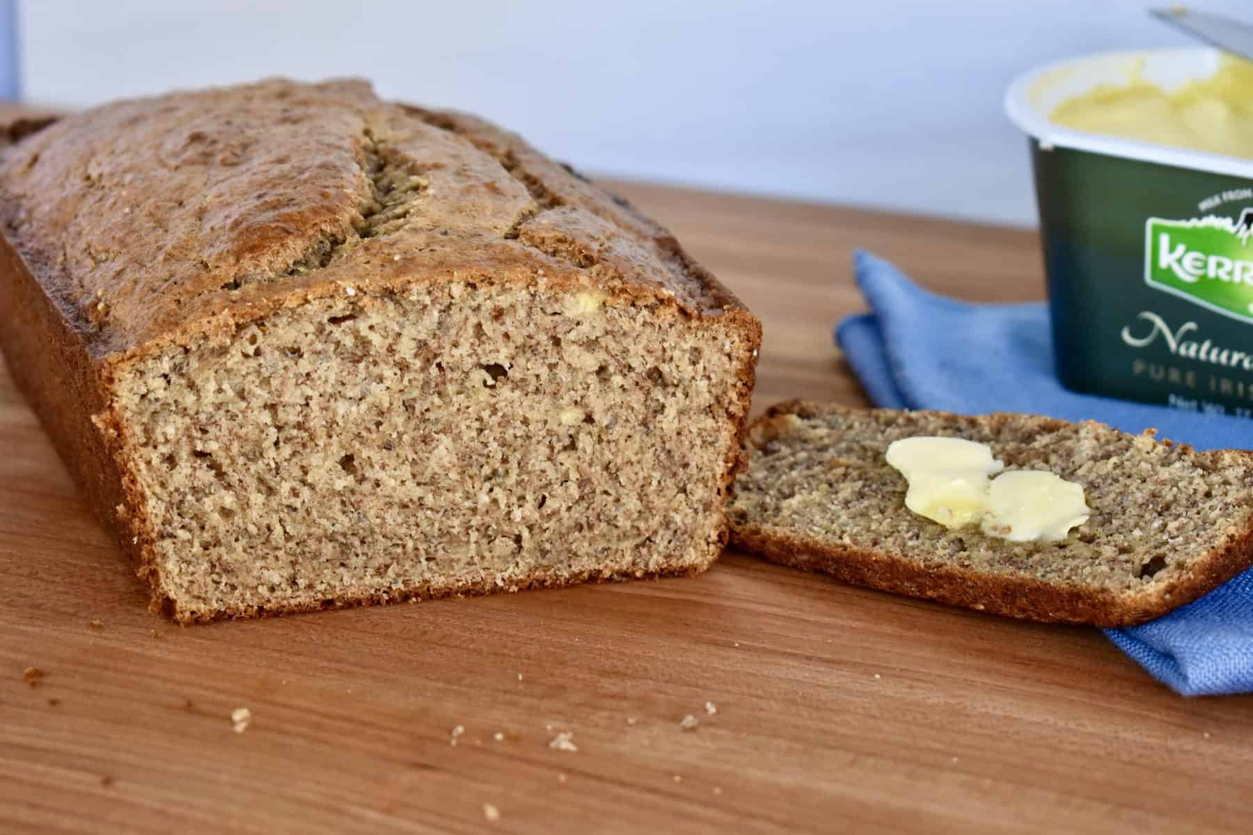 One Bowl Banana Bread on a cutting board with butter. 