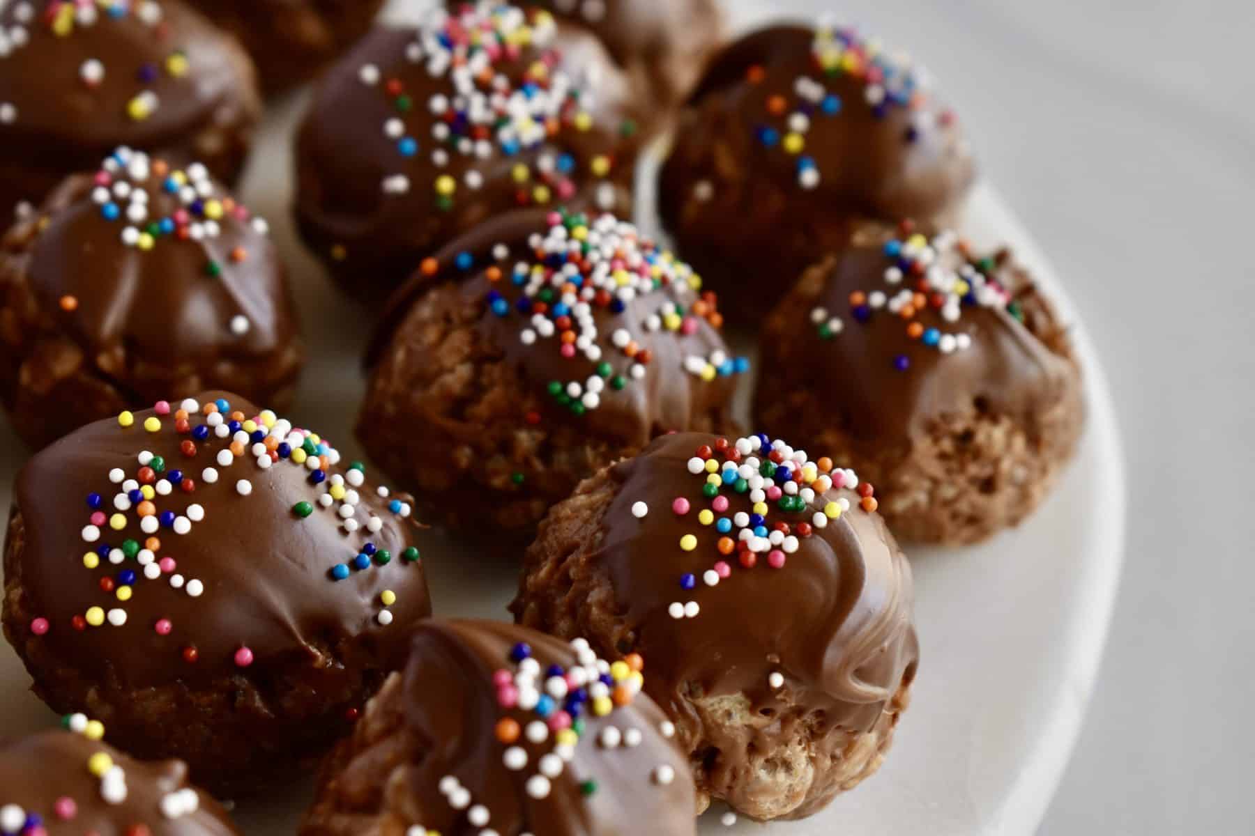 Crispy Nutella Truffles with chocolate and sprinkles on top on a white plate. 