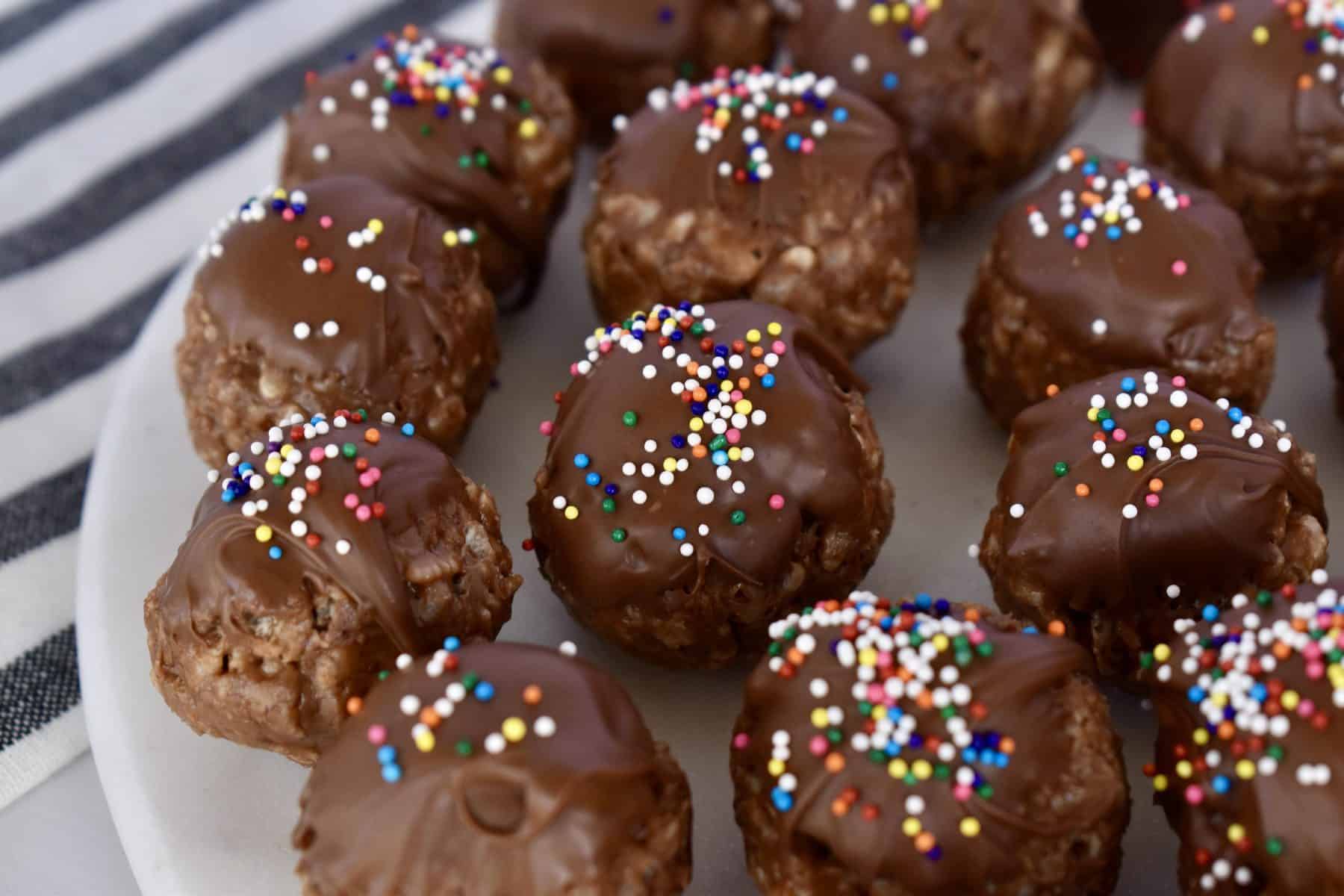 sprinkles on top of truffles on a white plate. 