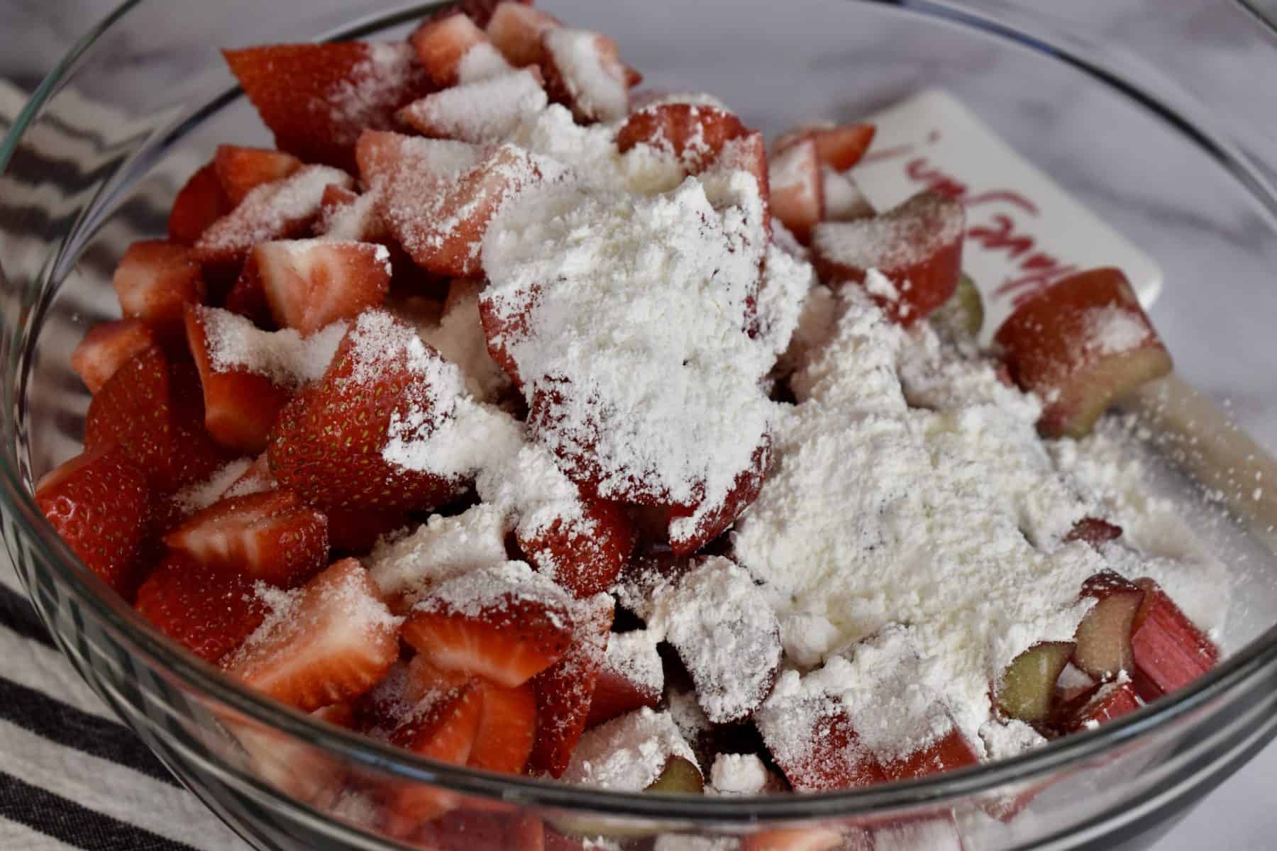 Rhubarb, strawberries, cornstarch, sugar, and salt in a glass mixing bowl. 