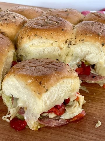 Antipasto Sliders on a wooden cutting board.