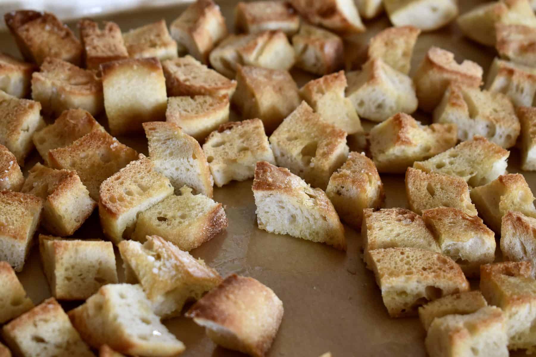 toasted bread cubes on a baking sheet. 