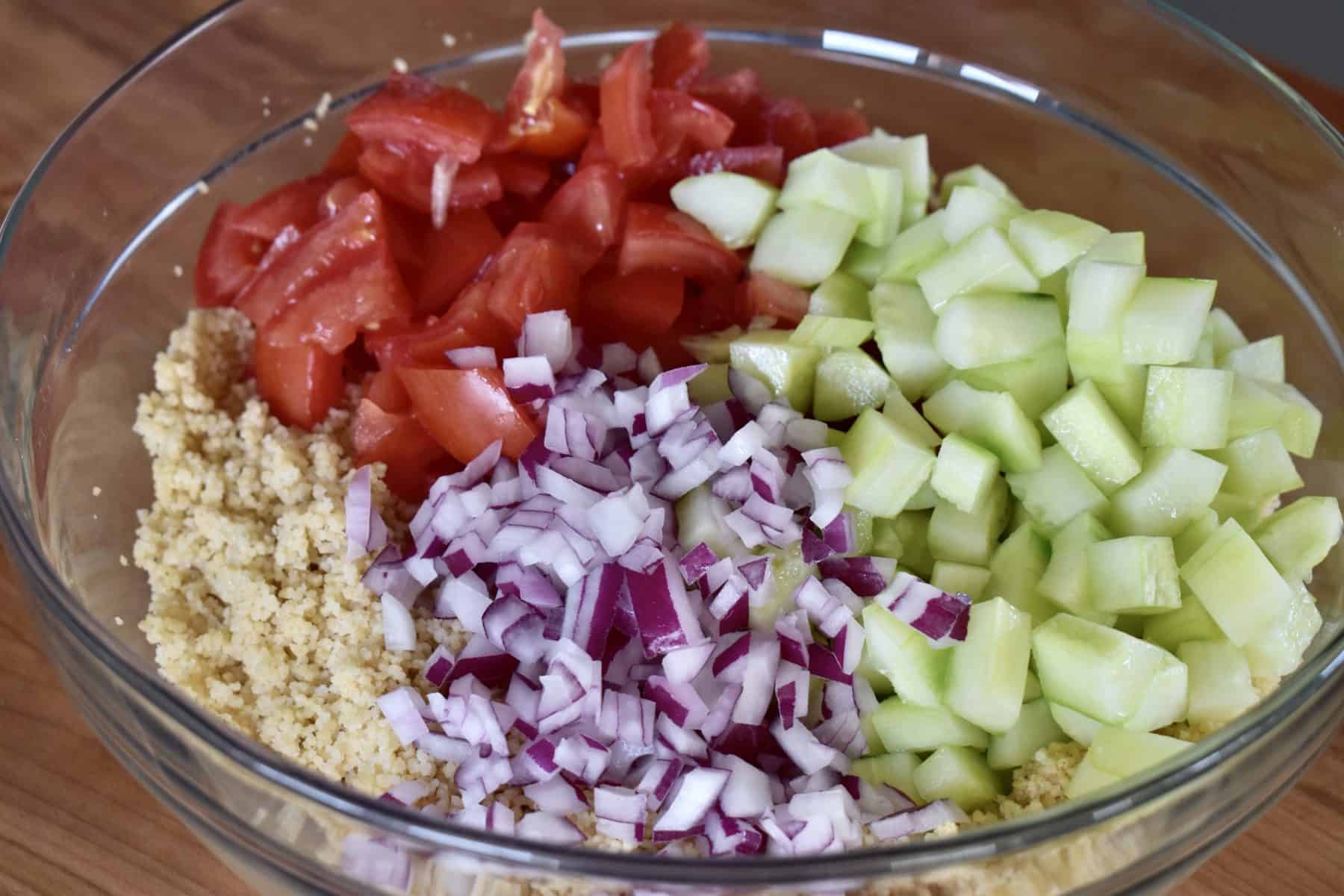 glass bowl with onion, tomato, and cucumbers. 