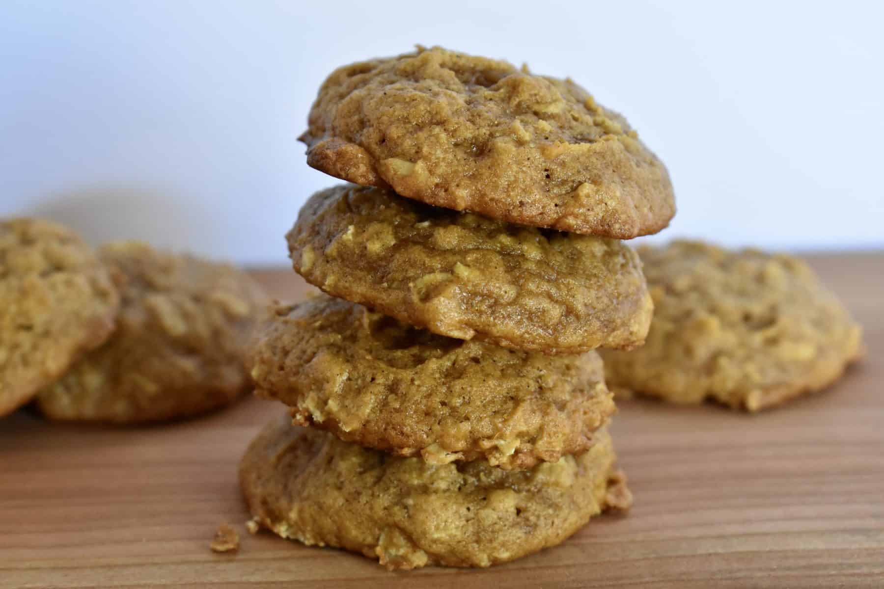 Oatmeal Pumpkin spice cookies piled on each other on a cutting board. 