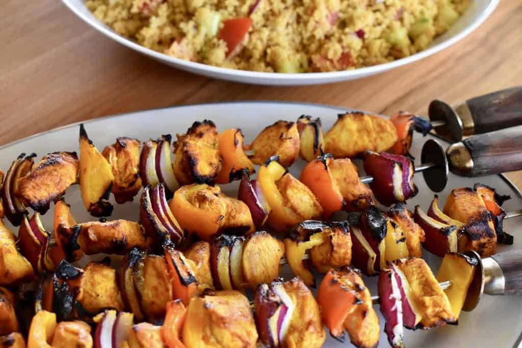 Grilled Chicken Kabob on a plate with couscous in the background. 