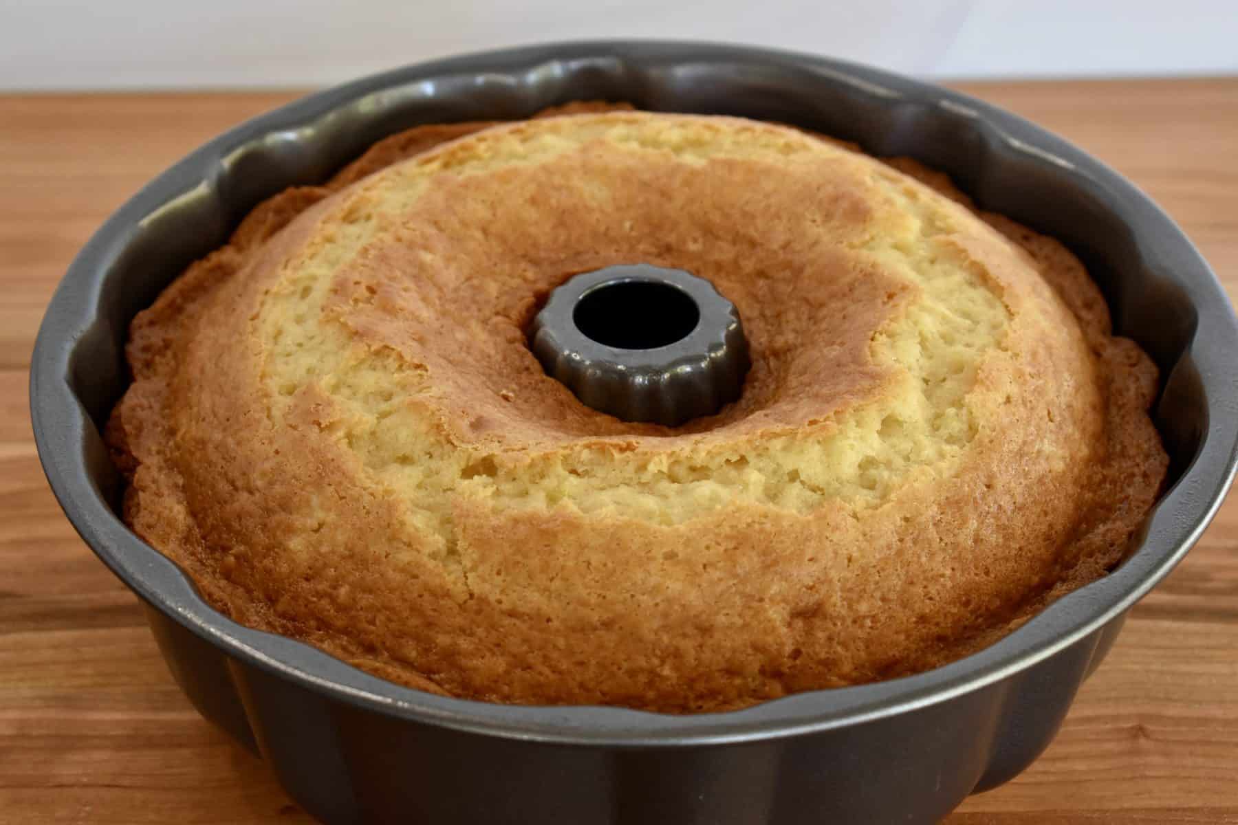 cooked pineapple cake in the Bundt Cake pan on a wooden surface. 