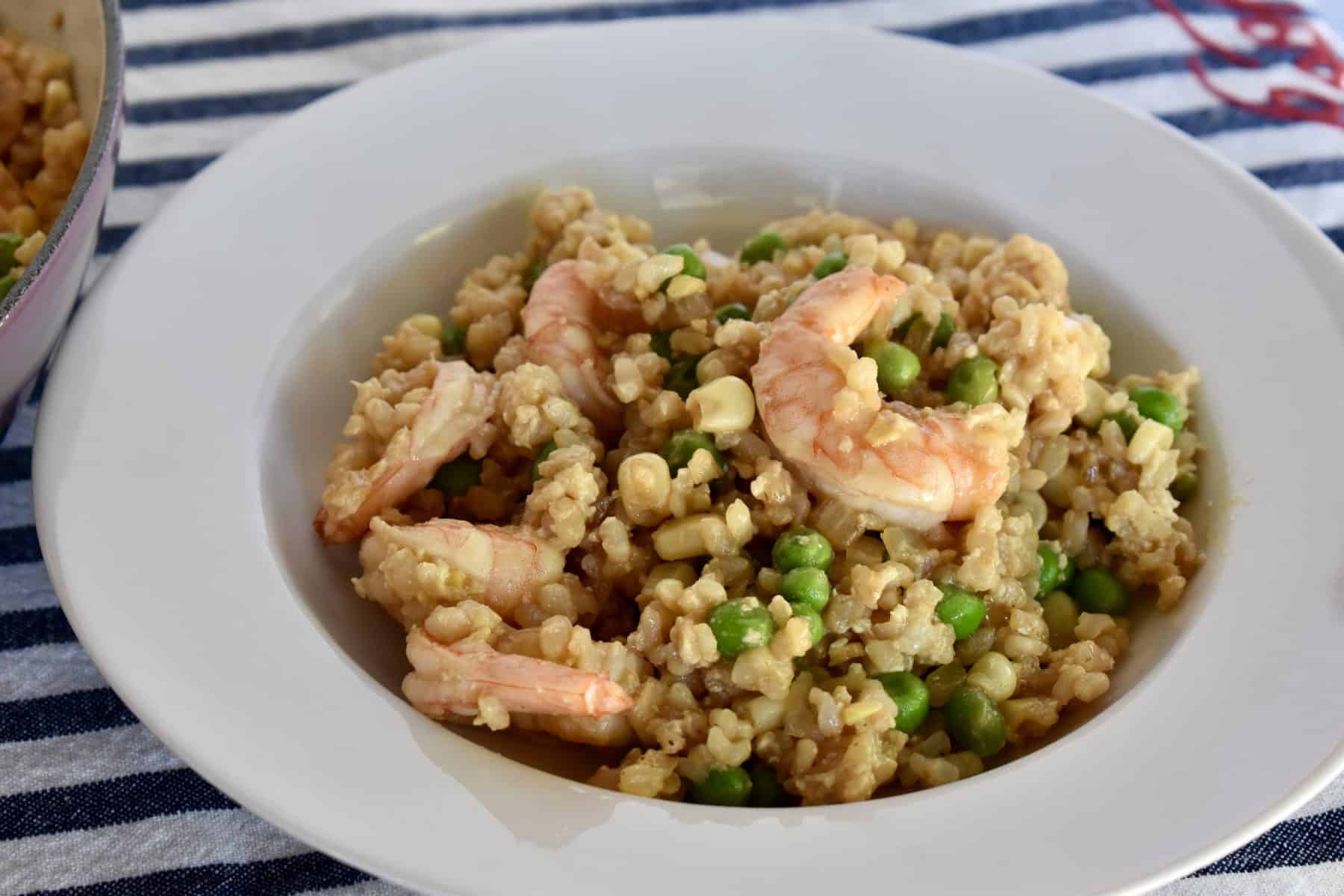 Shrimp Fried Brown Rice in a white bowl on a striped napkin. 