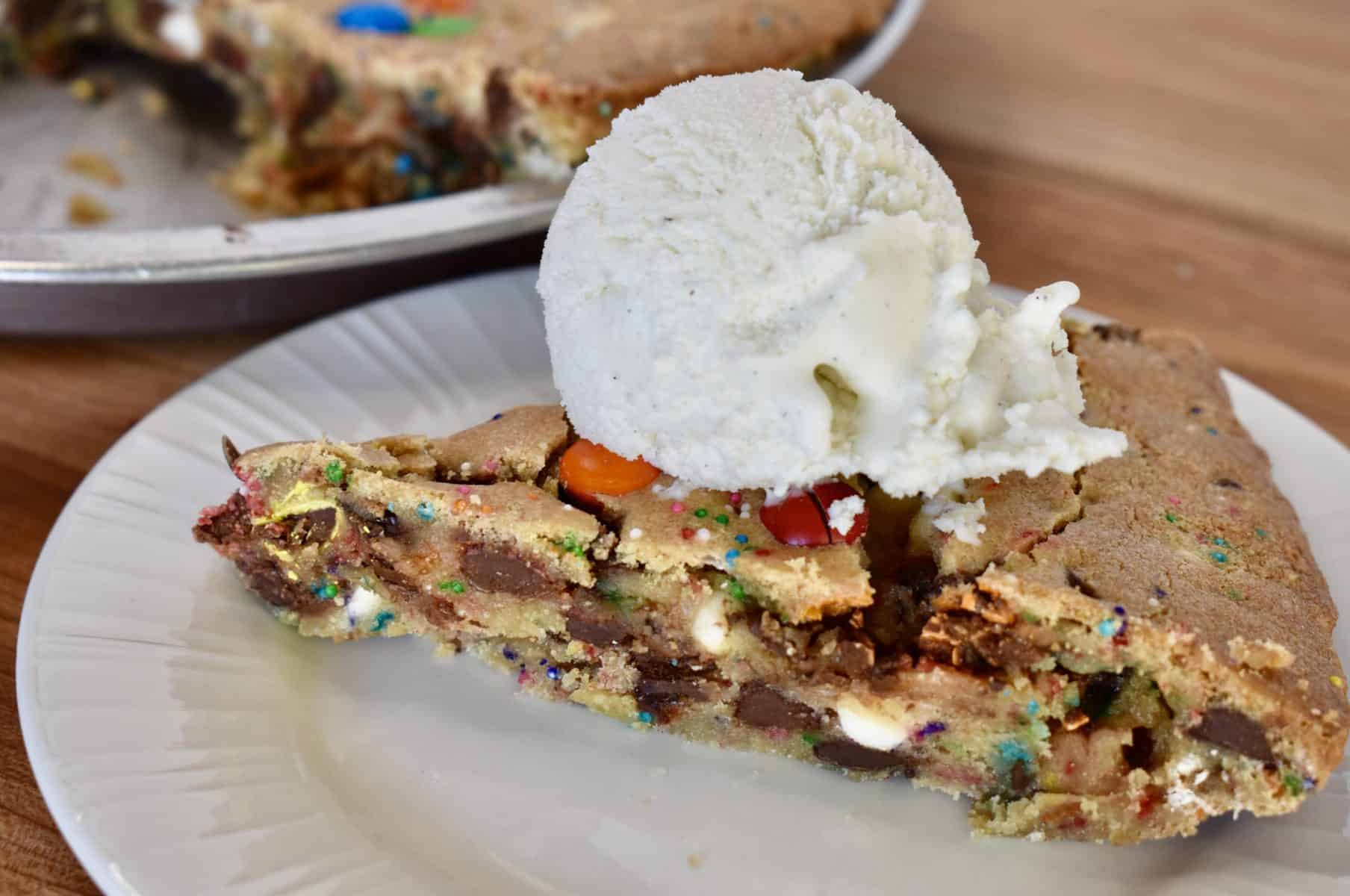 Loaded Cookie Pie on a plate with a scoop of ice cream. 