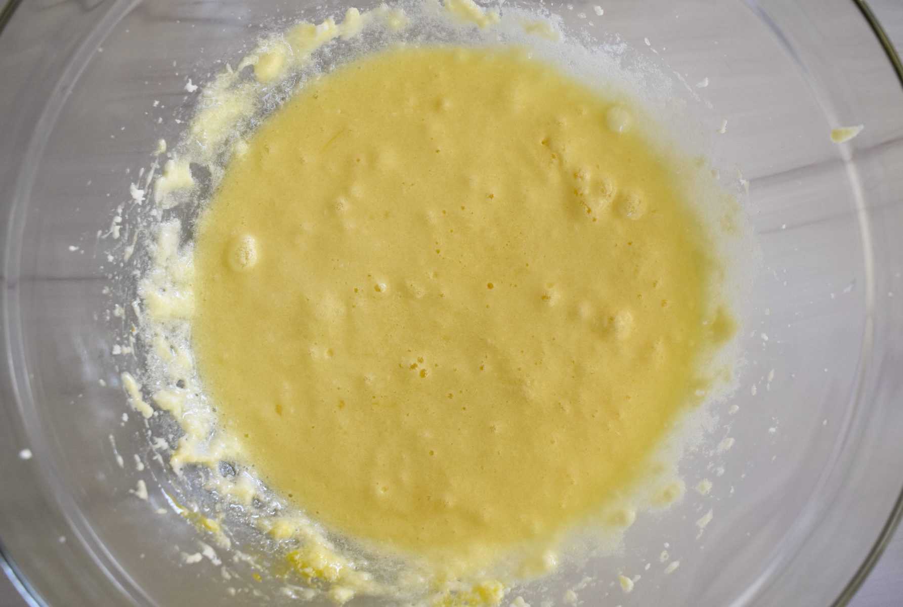 overhead photo of butter, sugar, and eggs mixed together in a glass bowl.
