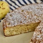 Almond Flour Pear Cake on a plate with pear in the background.