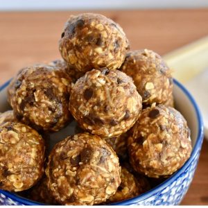 Chocolate coconut energy balls stacked high in a bowl.