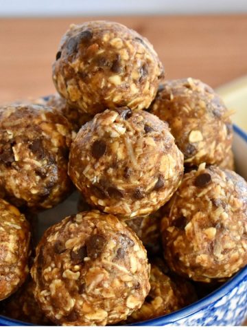Chocolate coconut energy balls stacked high in a bowl.