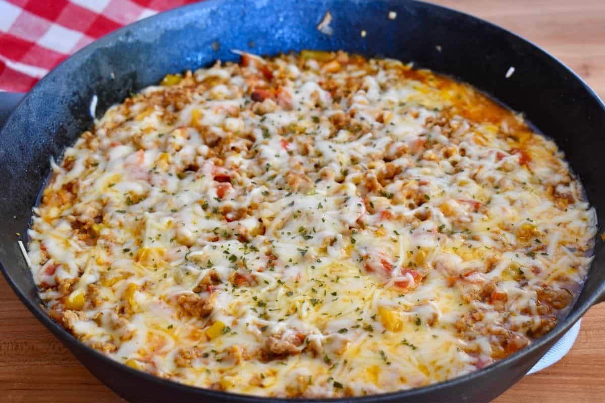 Unstuffed peppers with Italian sausage recipe in a large black cast iron skillet. 