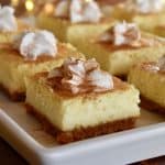 eggnog cheesecake bars on a white platter.