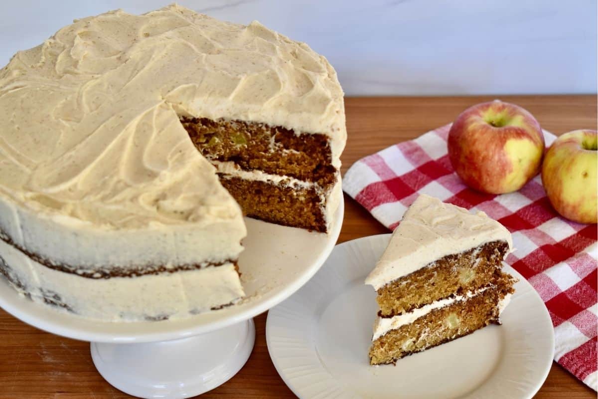 Apple Spice Cake on a plate with a cake on a pedestal next to it.