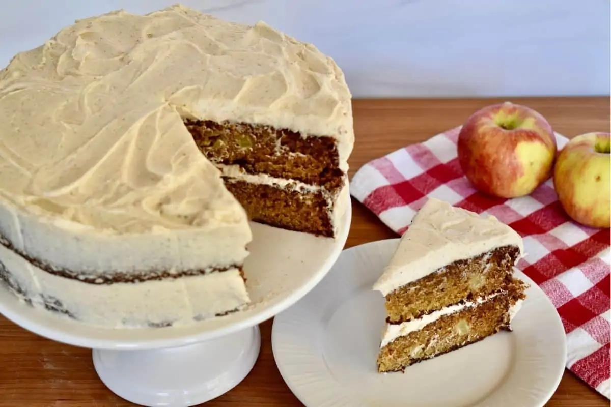 Apple Spice Cake on a plate with a cake on a pedestal next to it. 