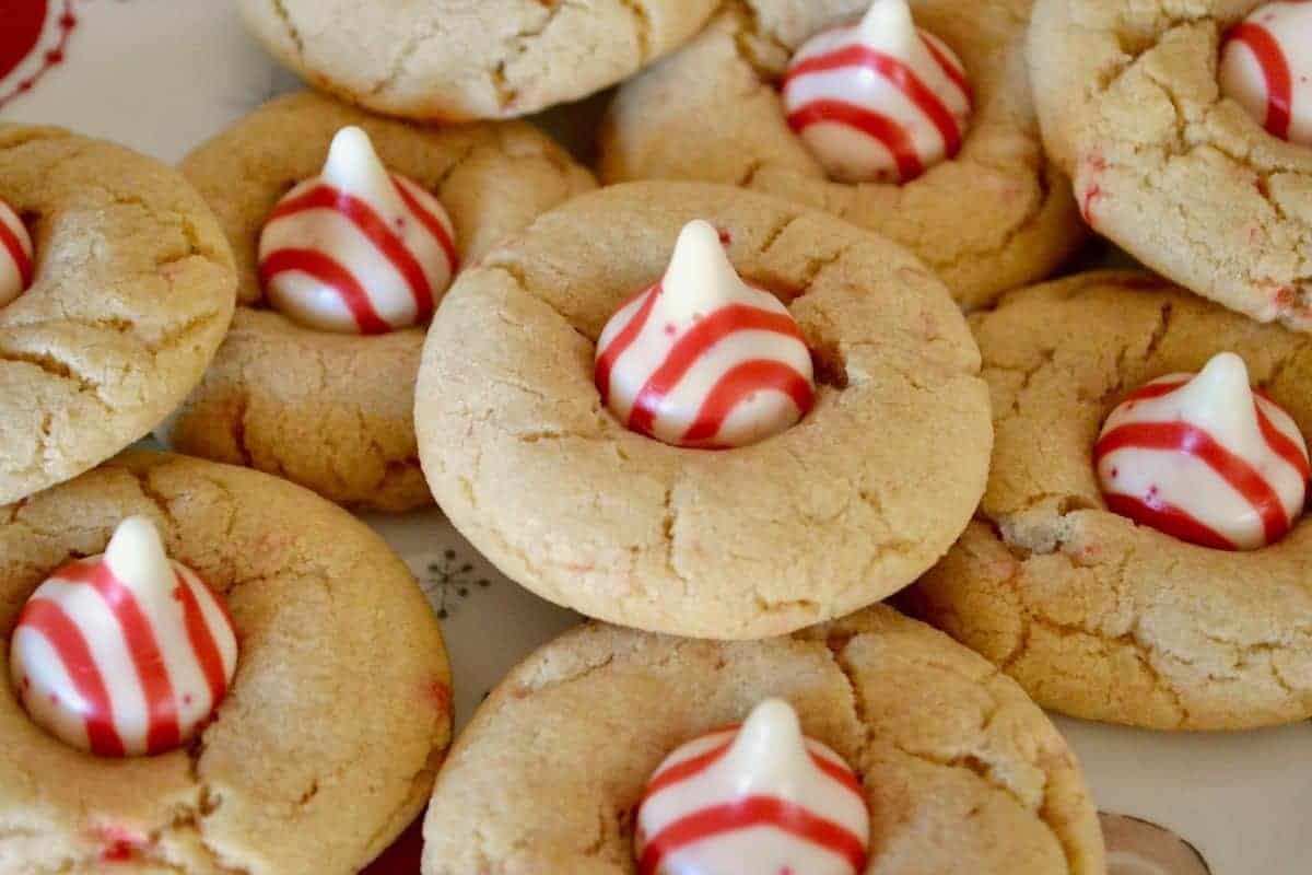 Candy Cane Kiss Cookies piled on a white plate. 