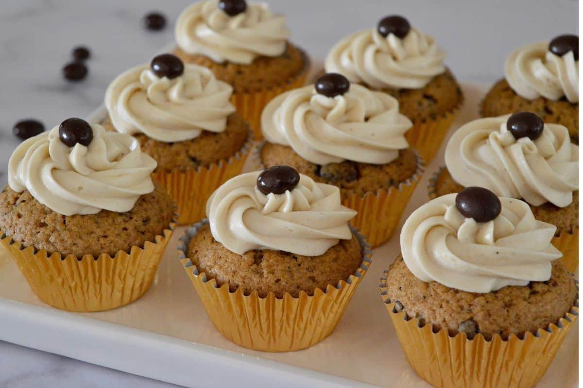 Espresso cupcakes on a white serving platter with a chocolate covered espresso bean on top - these are a best Christmas desserts recipe for sure!  