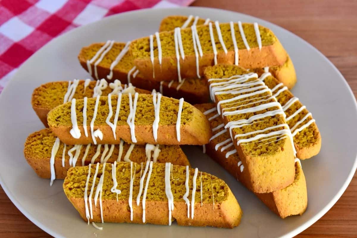 pumpkin biscotti with white chocolate drizzle piled high on a plate are definitely a best Christmas desserts recipe. 