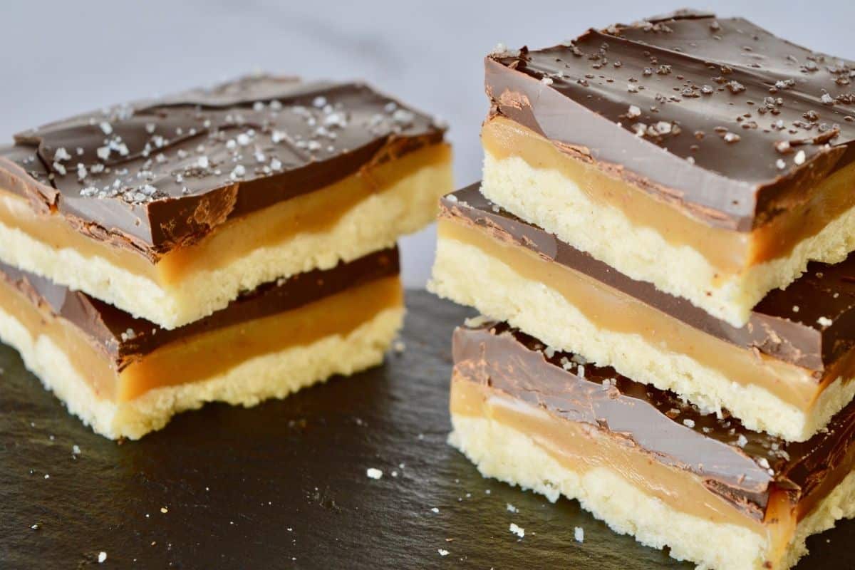 Salted Chocolate Caramel squares stacked on a plate are definitely a best Christmas desserts recipe! 