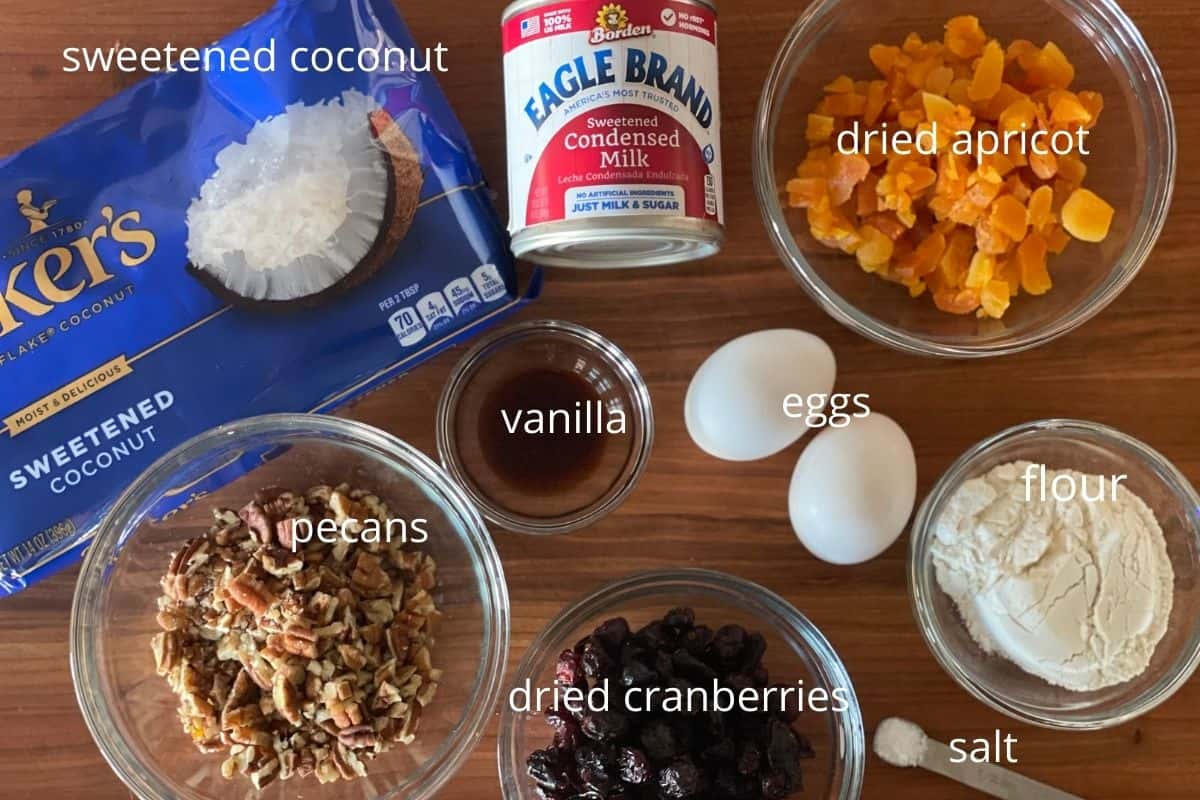 overhead photo of ingredients needed to make the cookies include eggs, sweetened condensed milk, and dried fruits and nuts. 