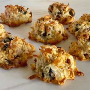 Coconut Macaroons with dried fruit and nuts on a white countertop.