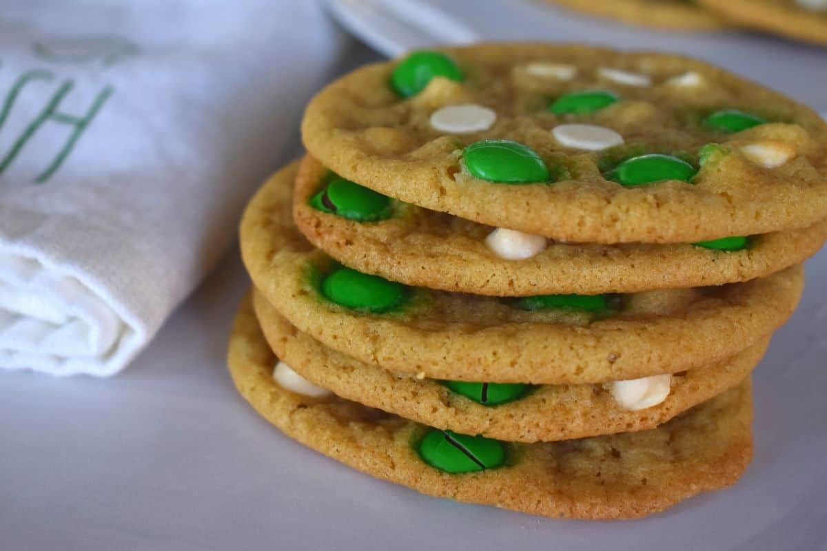 Stack of the cookie piled high with green M&M's in them. 