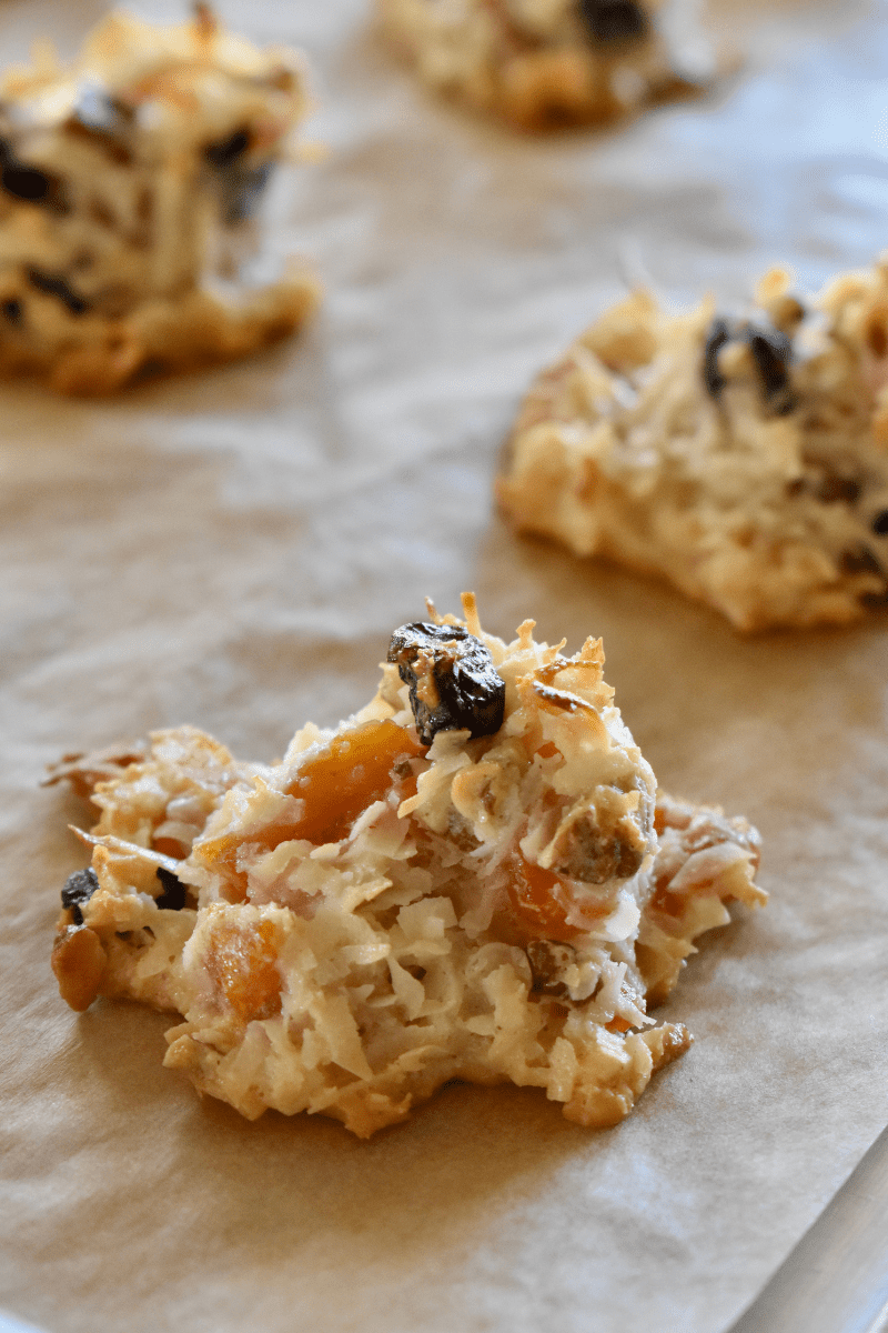 baked coconut and fruit macaroons on a parchment lined baking sheet. 