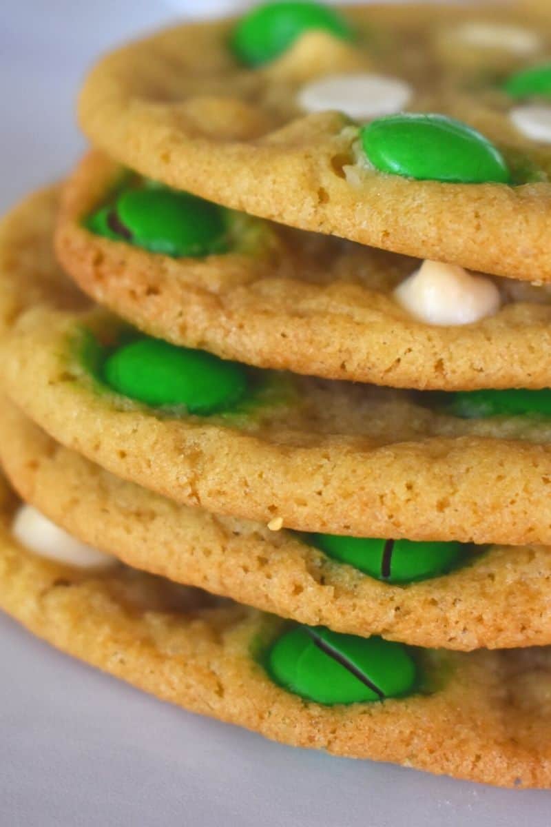 St. Patrick's Day Cookies with white chocolate and M&Ms stacked high on a white board. 