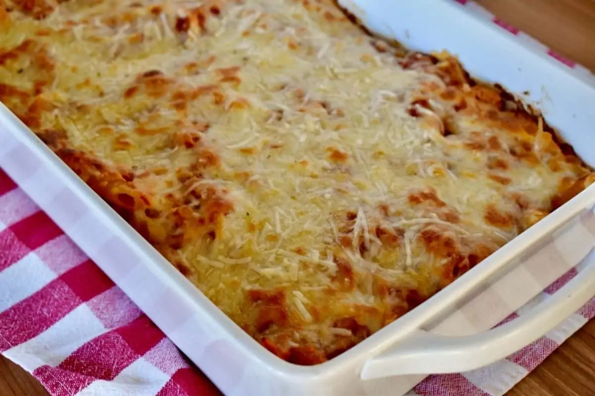 Large white casserole dish filled with the pasta and lots of melted mozzarella cheese on top. 