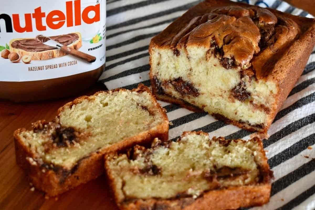 Nutella Swirl Banana Bread sliced with a jar of Nutella next to them.
