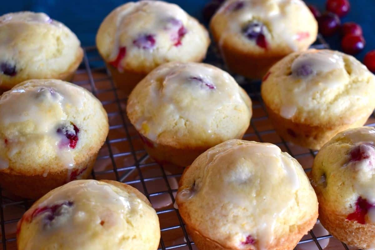 Cranberry Orange Muffins on a wire rack with cranberries in the background. 