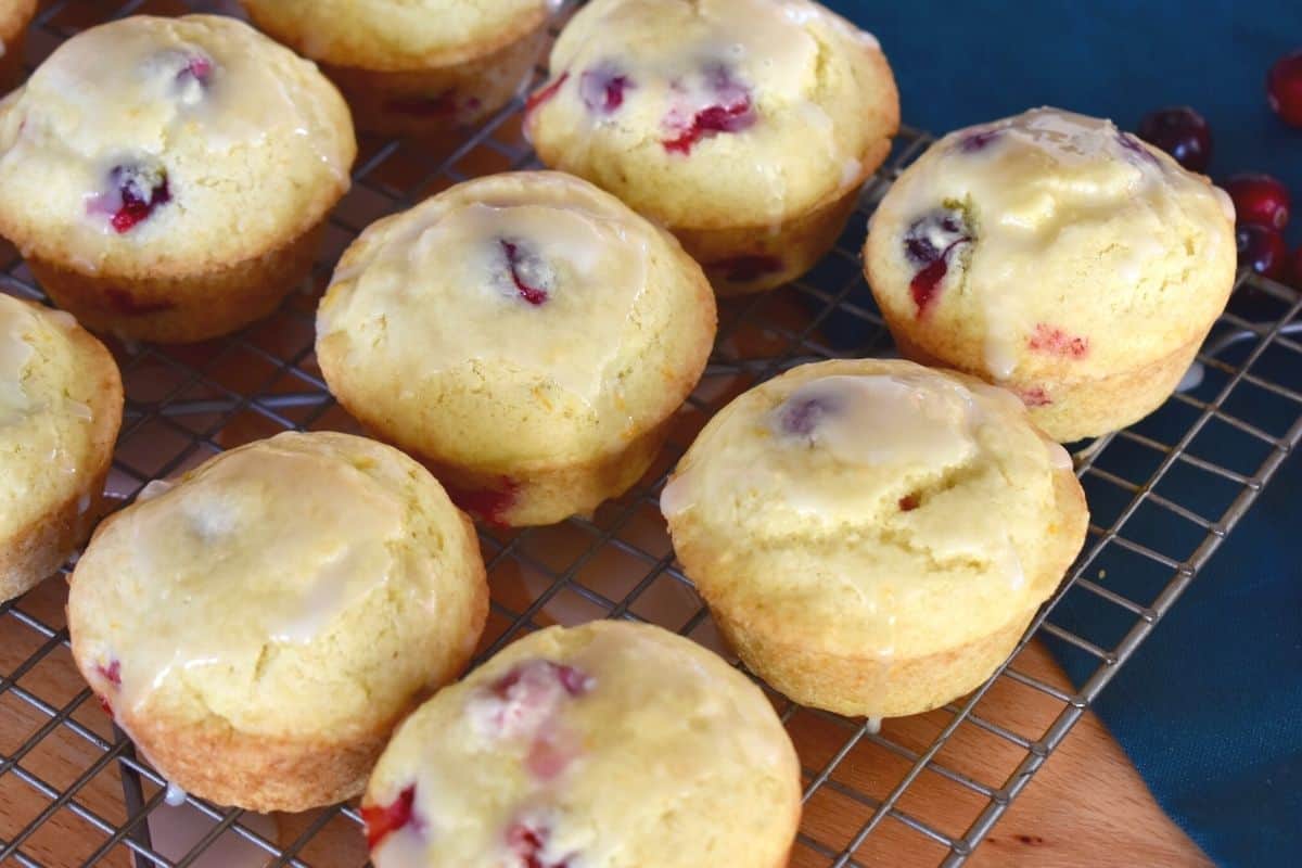 Cranberry Orange muffins on a wire cooling rack with a green towel underneath. 
