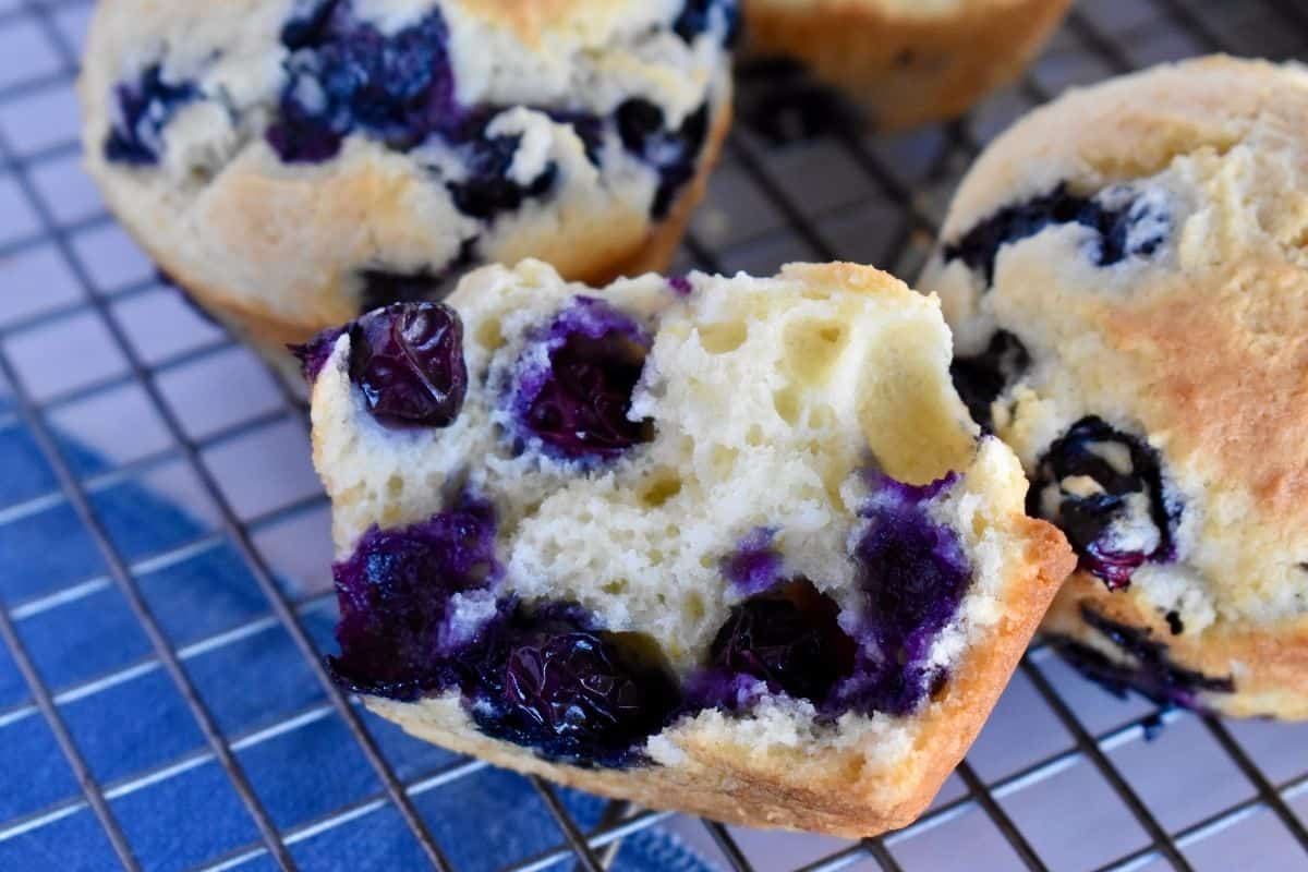 Blueberry Ricotta Muffin cut in half on a wire baking rack. 