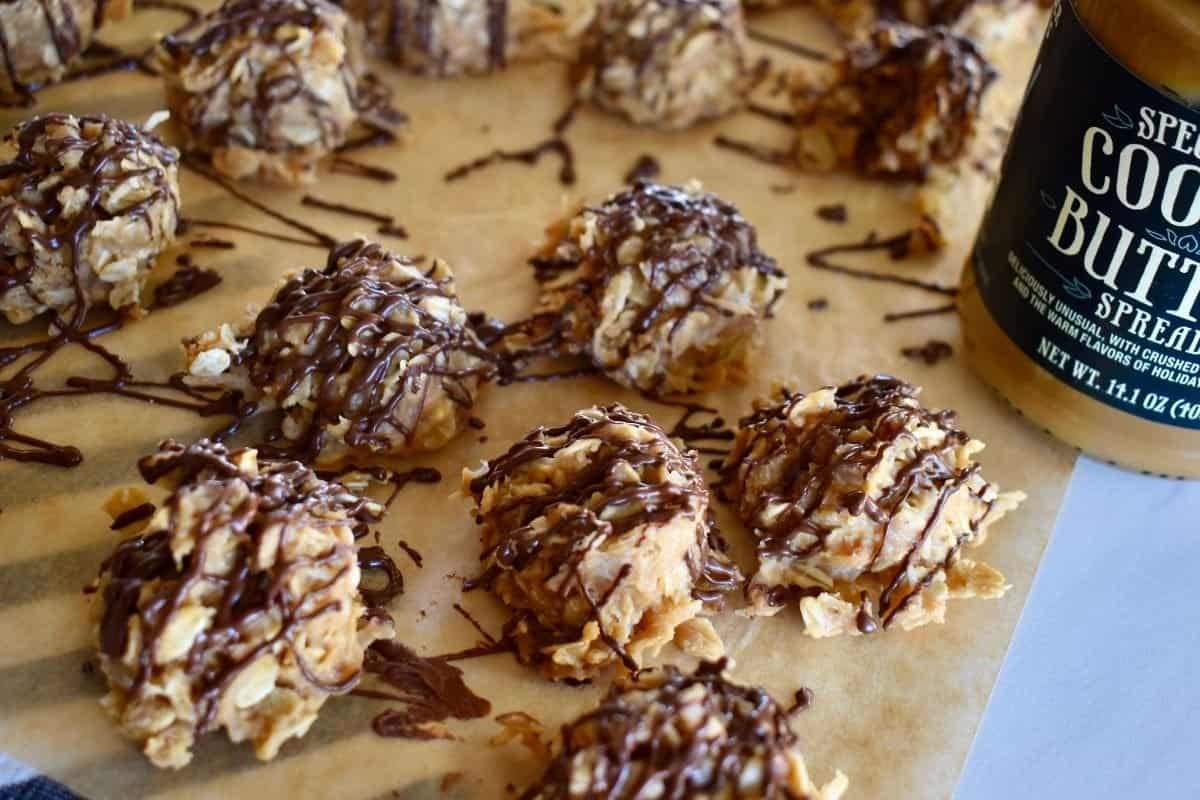 No Bake Cookie Butter Cookies on a piece of parchment with a drizzle of chocolate overtop. 