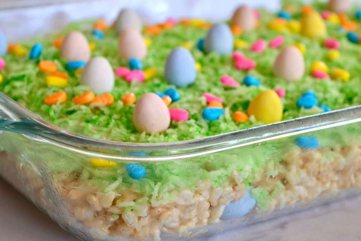 The recipe in a glass baking dish with shredded coconut and cadbury mini eggs on top.  