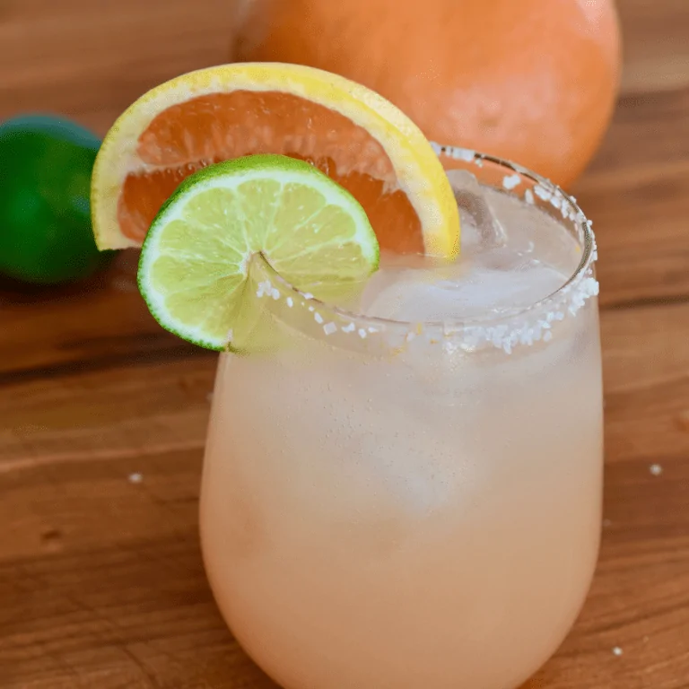 Grapefruit Paloma on countertop with a slice of grapefruit and lime on the rim.