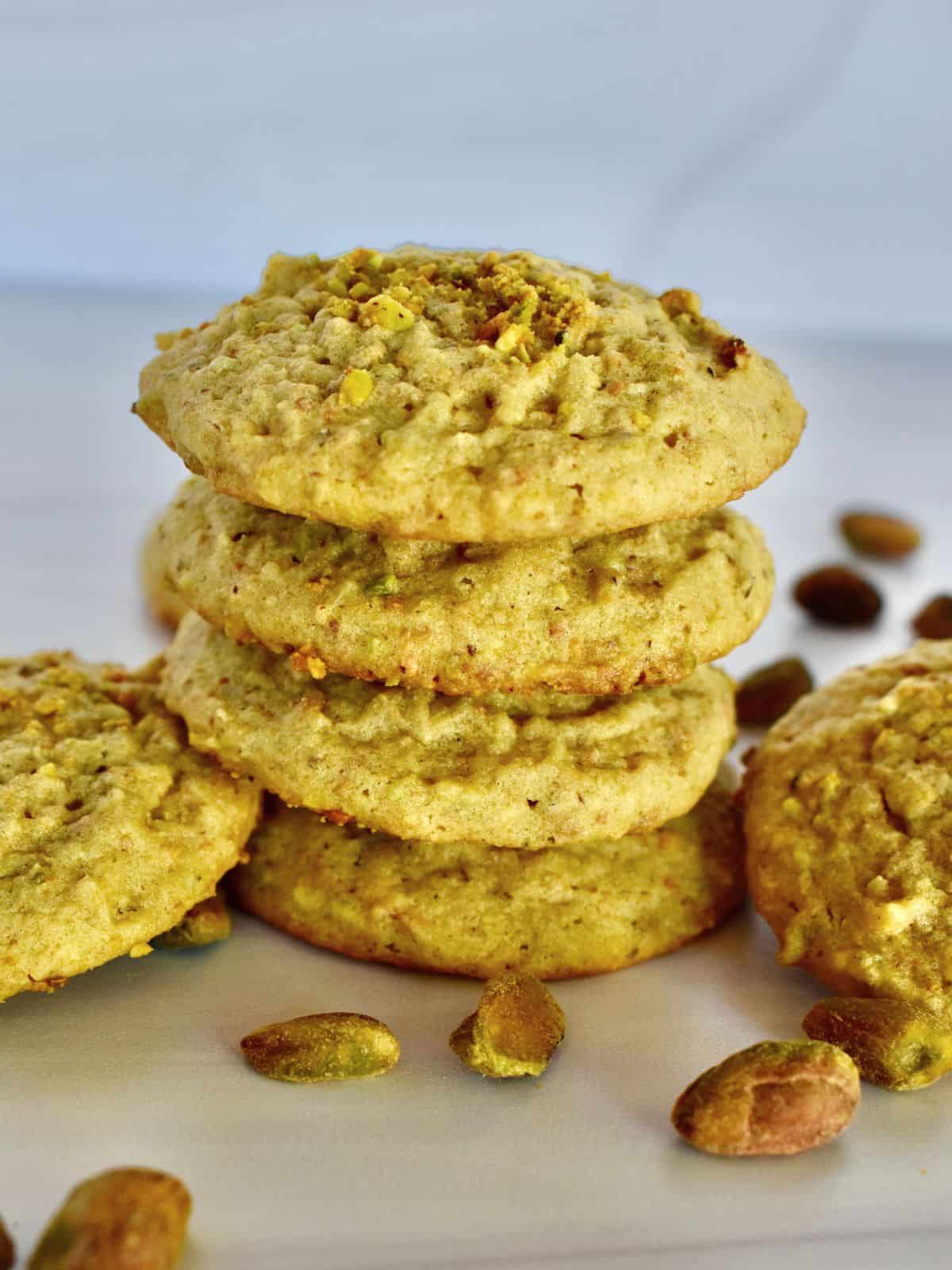 Italian Pistachio Cookies stacked on each other on a countertop. 
