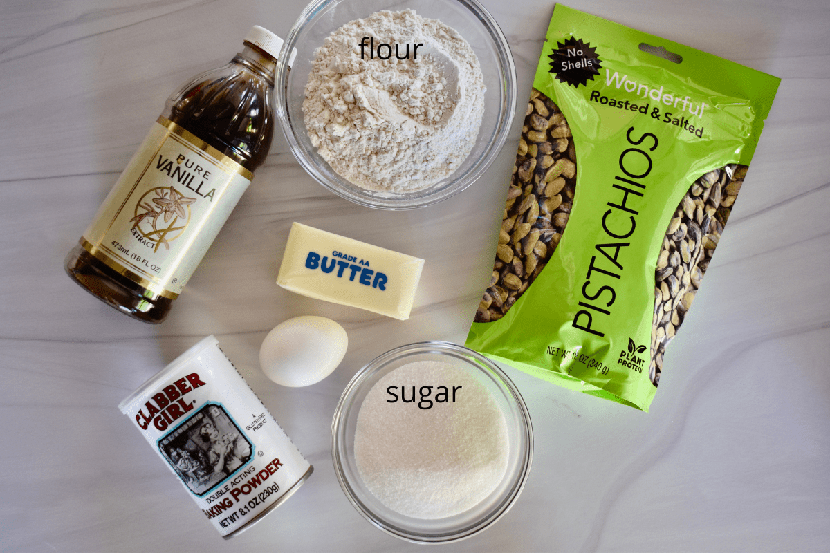 overhead photo of ingredients needed for recipe including butter, sugar, flour, egg, baking powder, and vanilla. 