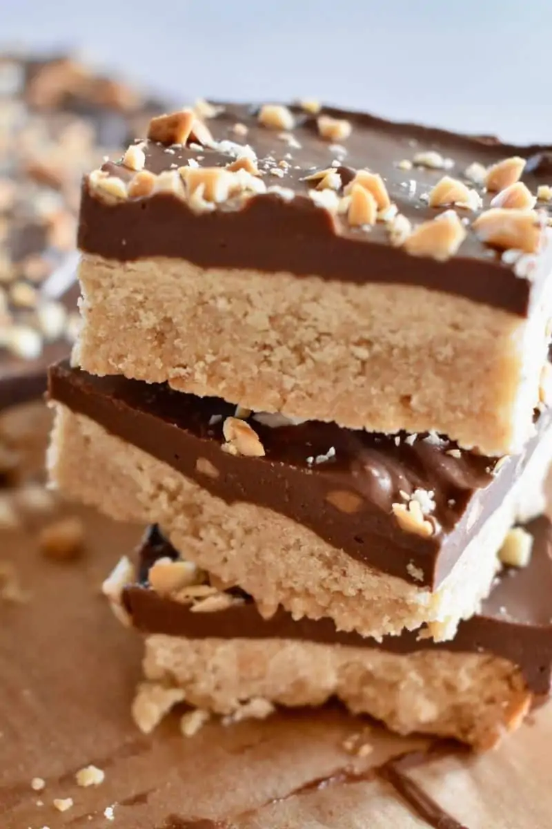 Peanut Butter Shortbread bars stacked on each other on a wood cutting board. 