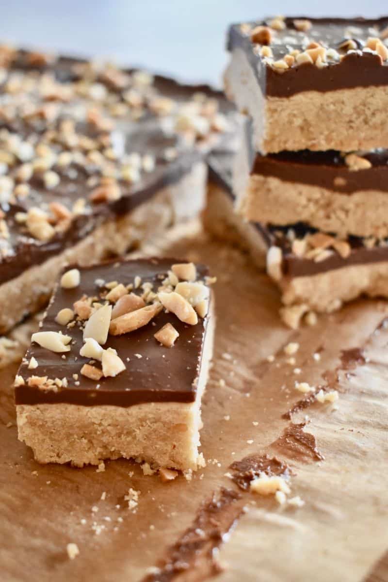 Peanut Butter Shortbread Bars on a cutting board with chopped peanut on top. 