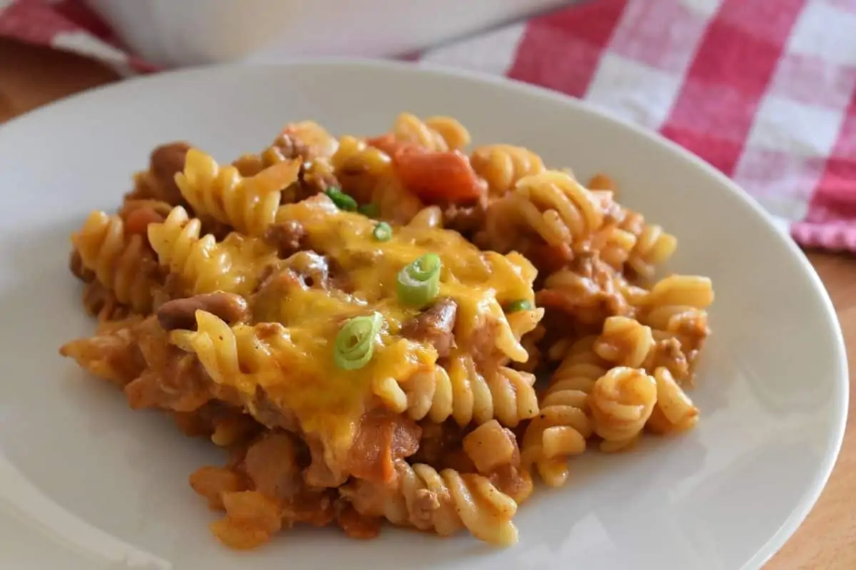 Chili Pasta Bake on a white plate with a checkered napkin in the background. 