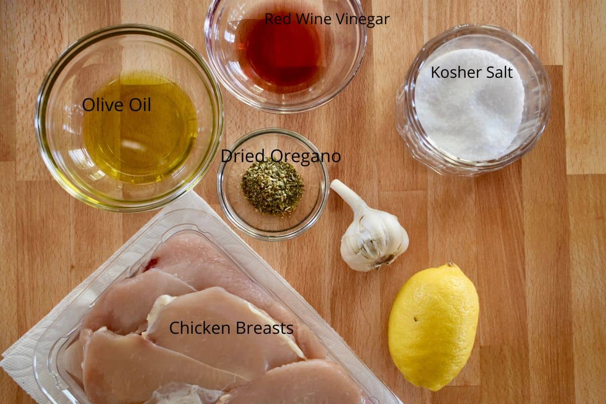 overhead photo of ingredients need to make recipe including olive oil, vinegar, garlic, salt, and lemon. 