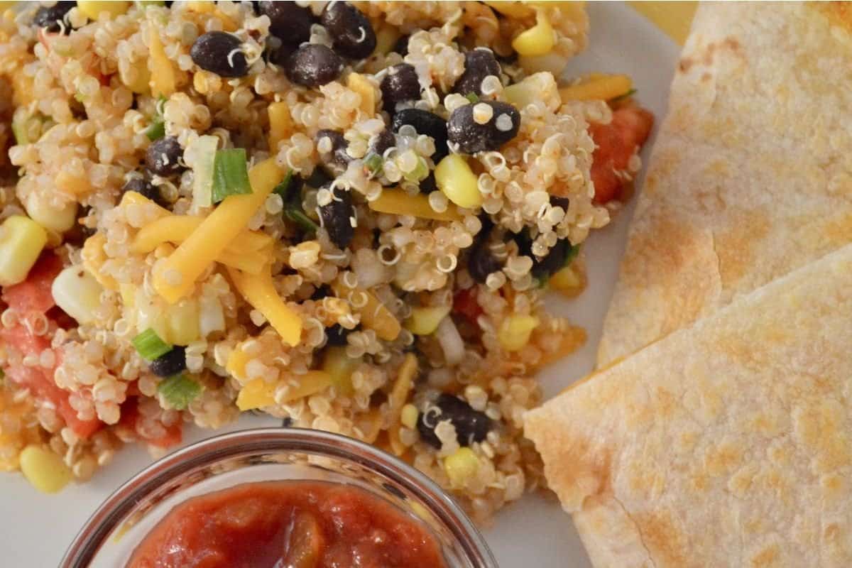 overhead photo of mexican quinoa salad on a plate with cheese quesadillas. 