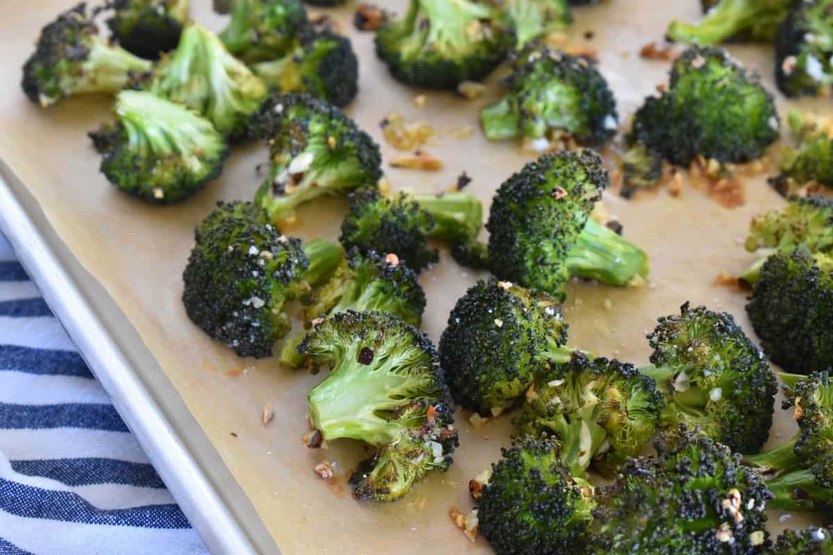 Oven Roasted Broccoli with Garlic and red pepper flakes on a lined baking sheet. 